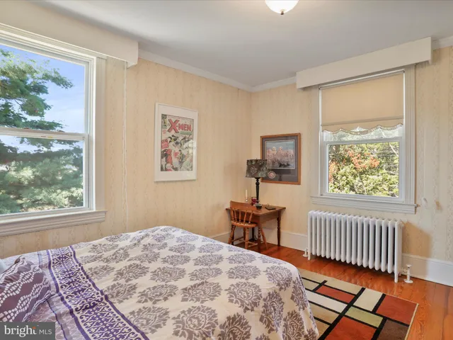 a bedroom with a bed and a window with chair