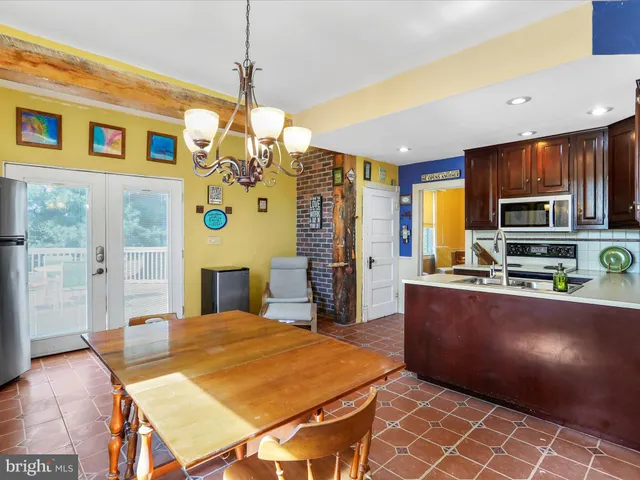 a kitchen with stainless steel appliances kitchen island granite countertop a refrigerator a stove top oven and a sink with dishwasher