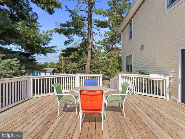 a balcony with wooden floor table and chairs