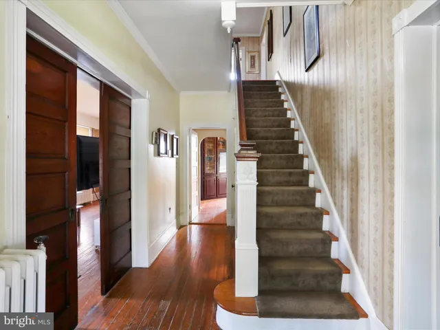 a view of entryway and hall with wooden floor