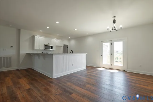 a view of a kitchen with wooden floor and a kitchen
