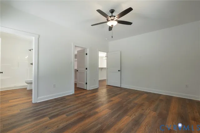 an empty room with wooden floor and ceiling fan