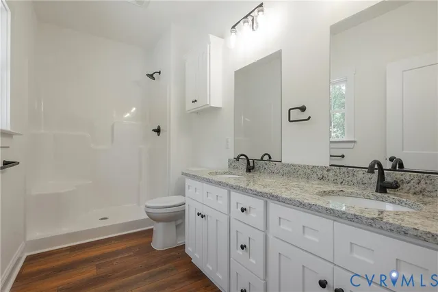 a bathroom with a granite countertop sink a toilet and a large mirror