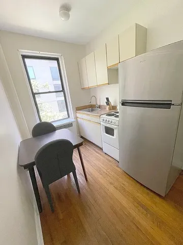 a kitchen with cabinets and wooden floor