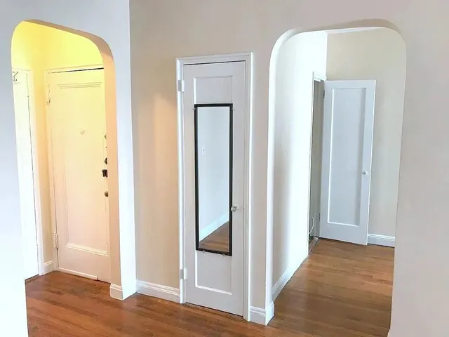 a view of a hallway with wooden floor