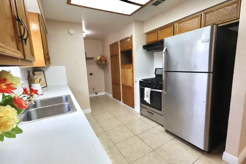 a kitchen with a sink a refrigerator and cabinets