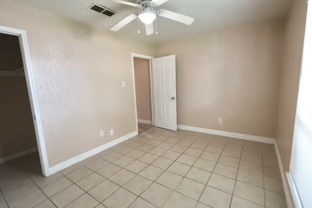 an empty room with closet and fan