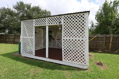 a view of a backyard with potted plants and large tree