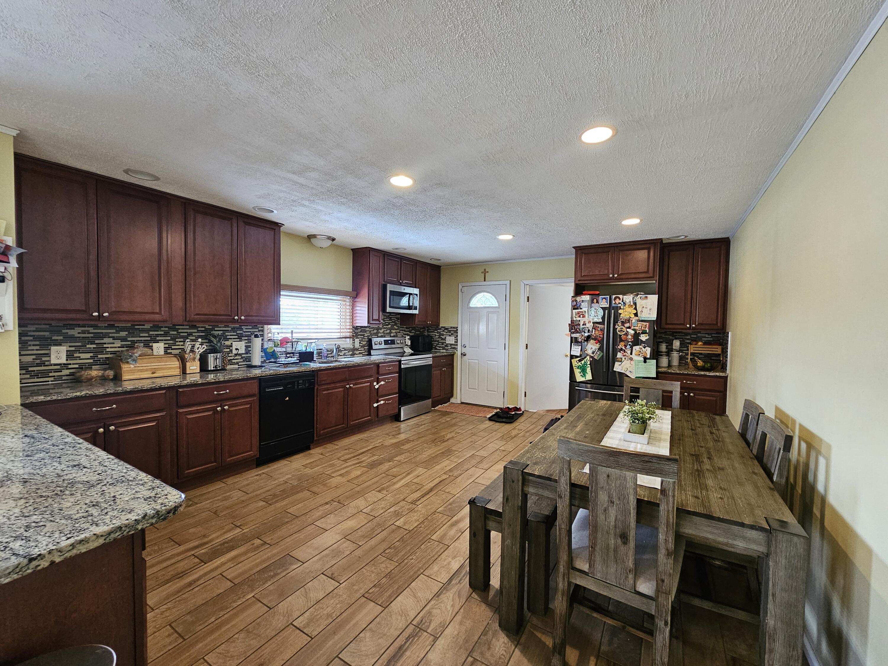117 Cross Street Pocono Lake, PA 18347 - Photo 6 of 26 a kitchen with stainless steel appliances granite countertop a sink dishwasher a stove a refrigerator with island and chairs