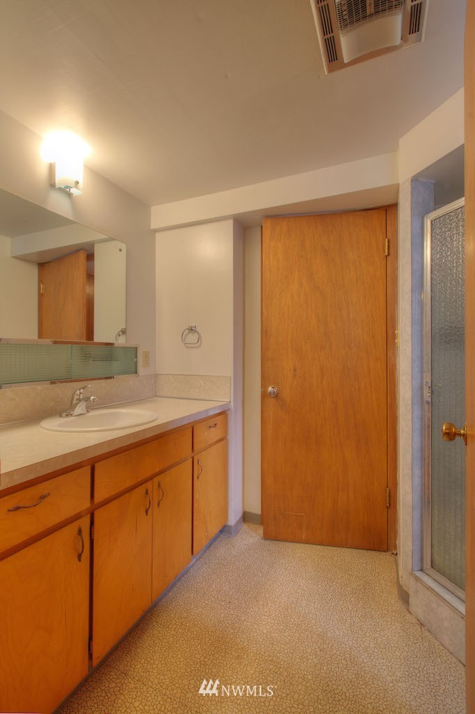 3020 Northwest 75th Street Seattle, WA 98117 - Photo 16 of 22 a bathroom with a granite countertop sink and a mirror
