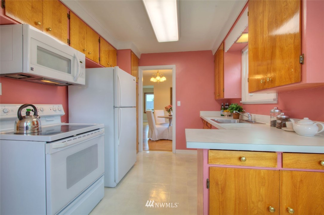3020 Northwest 75th Street Seattle, WA 98117 - Photo 8 of 22 a kitchen with stainless steel appliances granite countertop a sink and a refrigerator