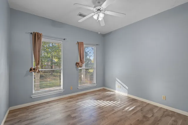 a view of an empty room with window chandelier fan