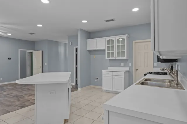 a kitchen with a stove and white cabinets