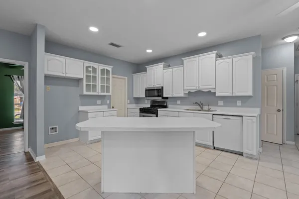 a view of kitchen with granite countertop cabinets and refrigerator