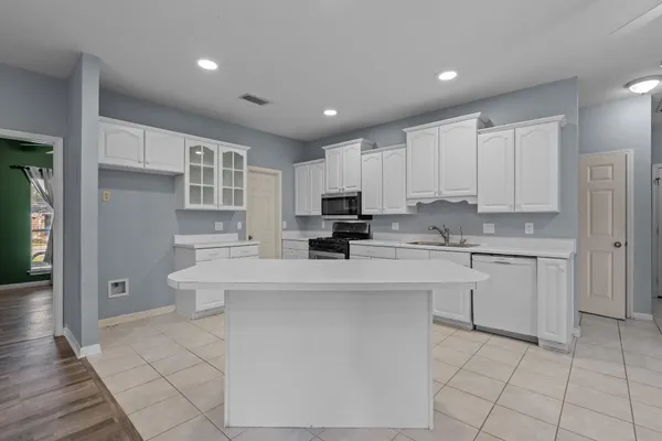 a view of kitchen with granite countertop cabinets and refrigerator