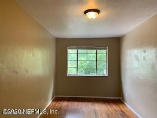 2117 Spring Park Road, Unit 4 Jacksonville, FL 32207 - Photo 7 of 9 an empty room with wooden floor and windows