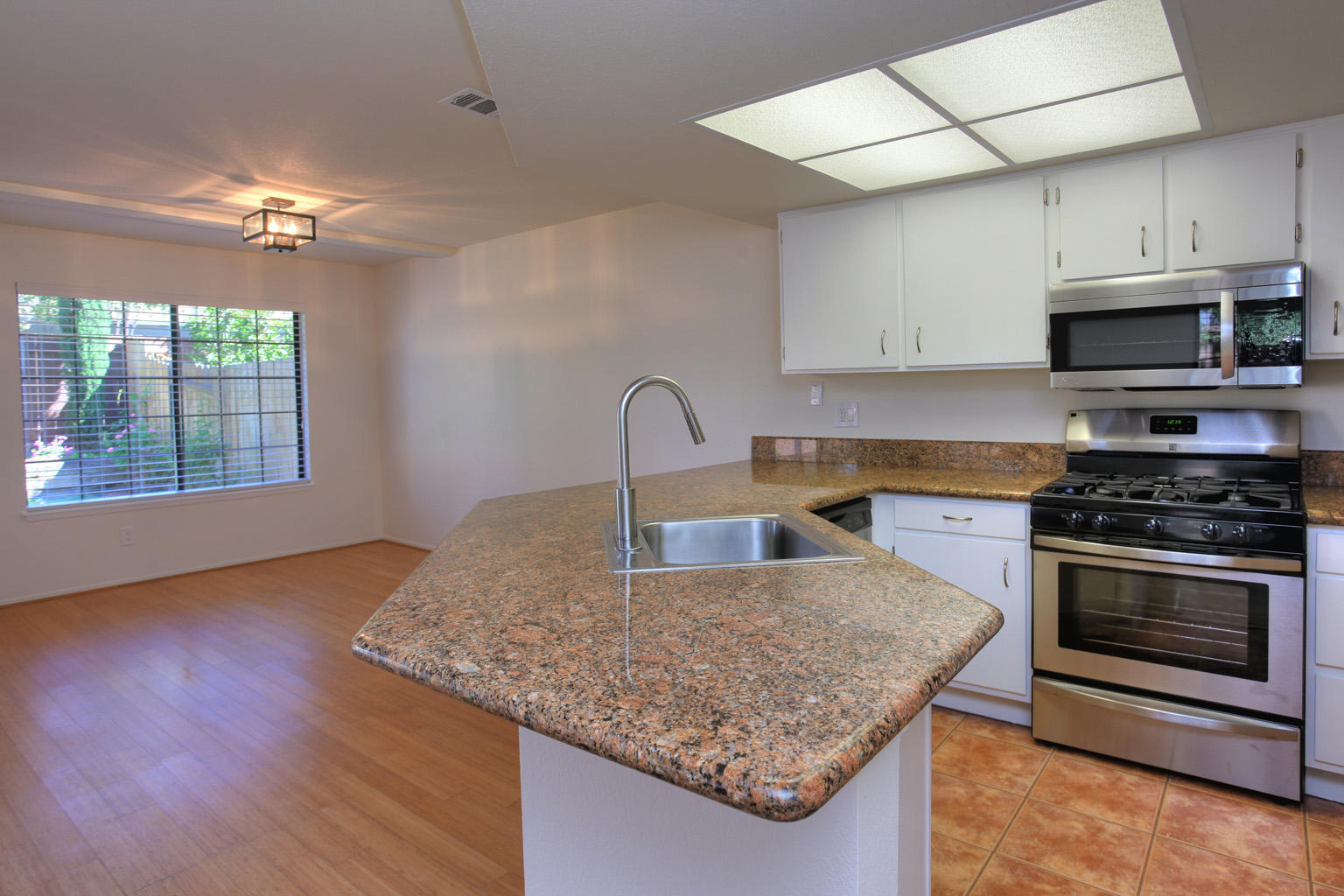 1493 Aarhus Drive, Unit 7 Solvang, CA 93463 - Photo 8 of 24 a kitchen with granite countertop a stove a sink and a microwave
