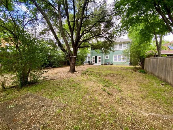 a yellow house with trees in front of it