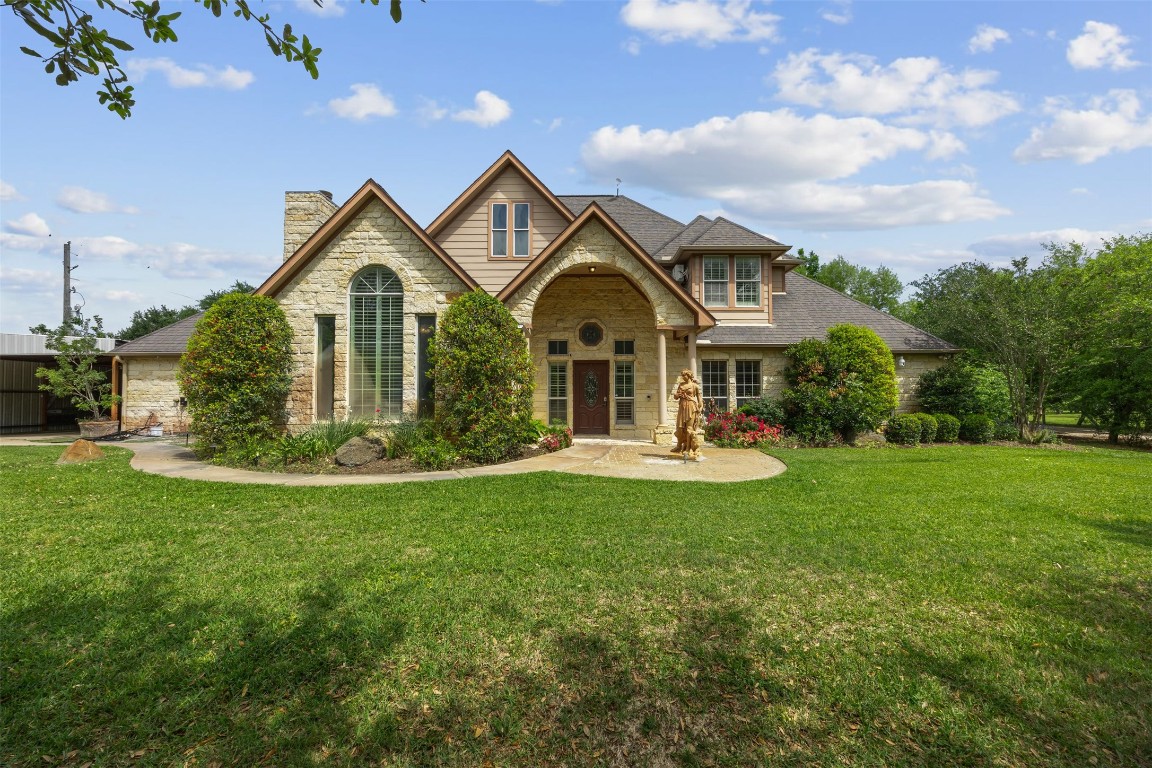 a front view of a house with yard and green space
