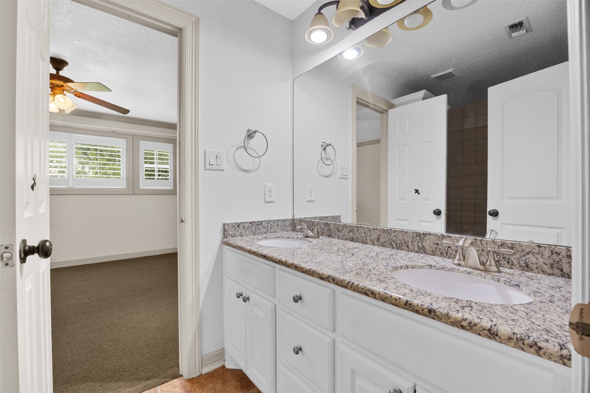 2622 Muegge Road Rosenberg, TX 77471 - Photo 26 of 35 a bathroom with a granite countertop sink a mirror and a shower