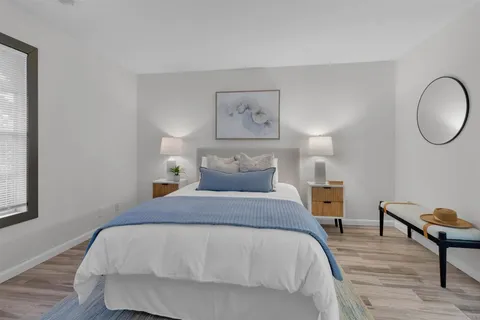 a spacious bedroom with a bed a table and chair