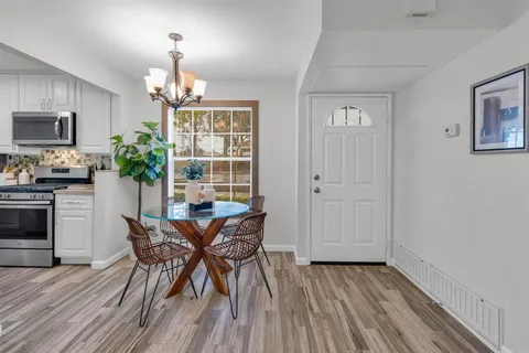 a view of a dining room with furniture and chandelier