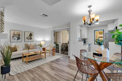 a living room with furniture a chandelier and a dining table