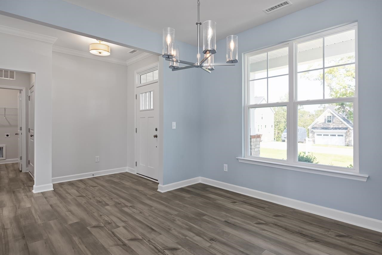 82 Morningside Lane Angier, NC 27501 - Photo 4 of 28 an empty room with wooden floor chandelier and windows
