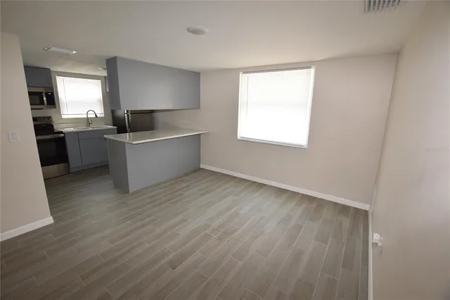 a large kitchen with a wooden floor and a sink