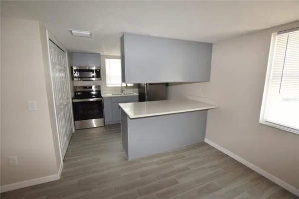 a view of kitchen with stainless steel appliances cabinets and wooden floor