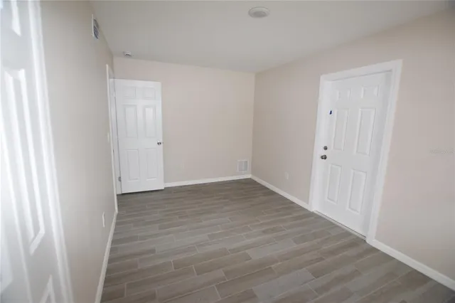 a view of an empty room with wooden floor