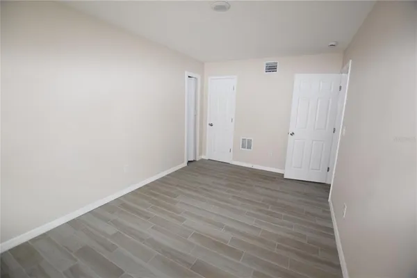 a view of an empty room with wooden floor