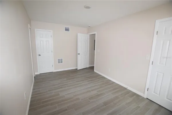 a view of an empty room with wooden floor