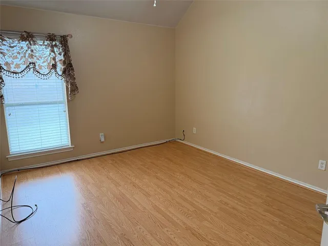 a view of a room with wooden floor and window