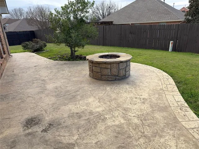 a view of a backyard with plants and fence