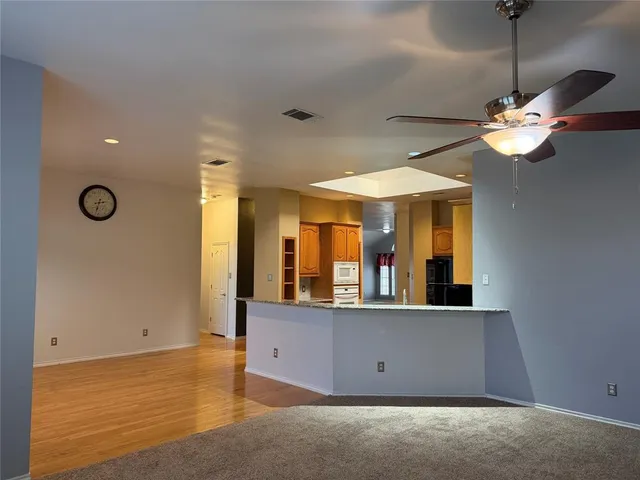 a view of a room with a chandelier fan and windows