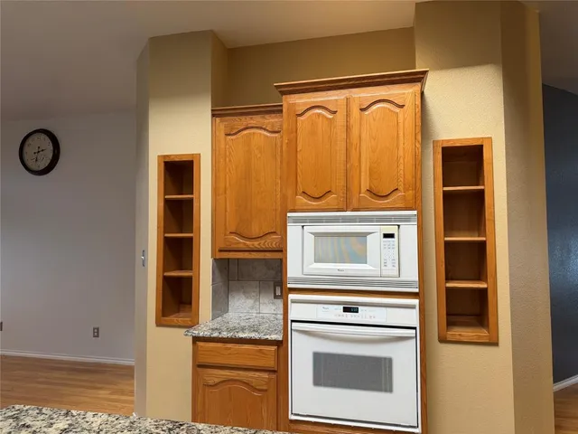 a kitchen with stainless steel appliances granite countertop a stove a sink and a microwave