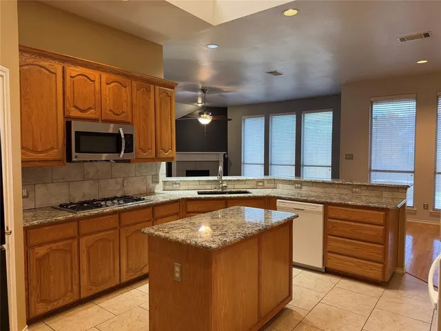 a large kitchen with a sink and a microwave
