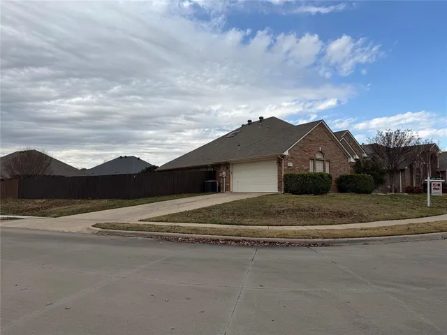 a view of dirt road with a large building