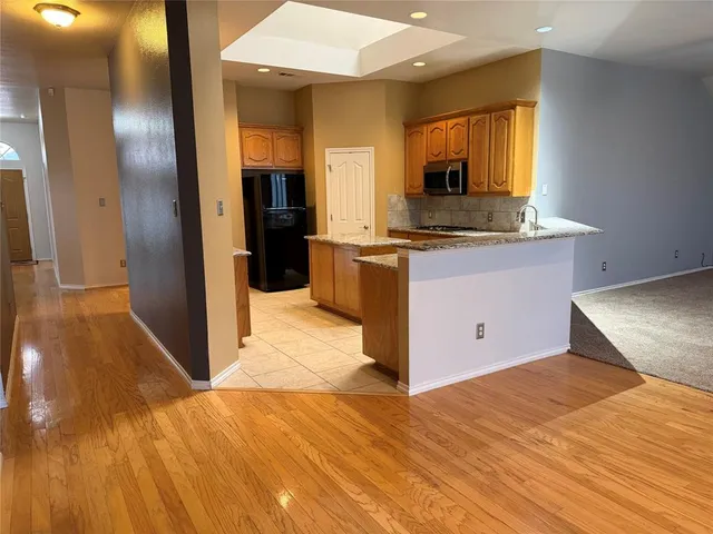 a kitchen with stainless steel appliances granite countertop a refrigerator and a sink