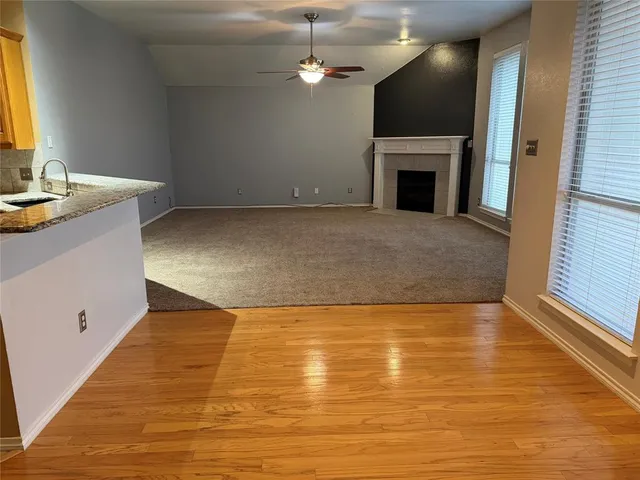 a view of an empty room with a fireplace and a window