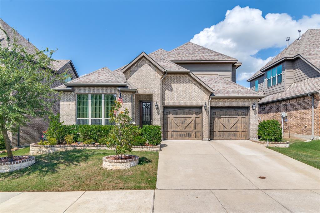 780 Mountcastle Drive Rockwall, TX 75087 - Photo 1 of 1 View of front of property featuring roof with shingles, brick siding, concrete driveway, a front yard, and an attached garage
