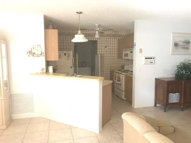 a view of a hallway with furniture and a chandelier