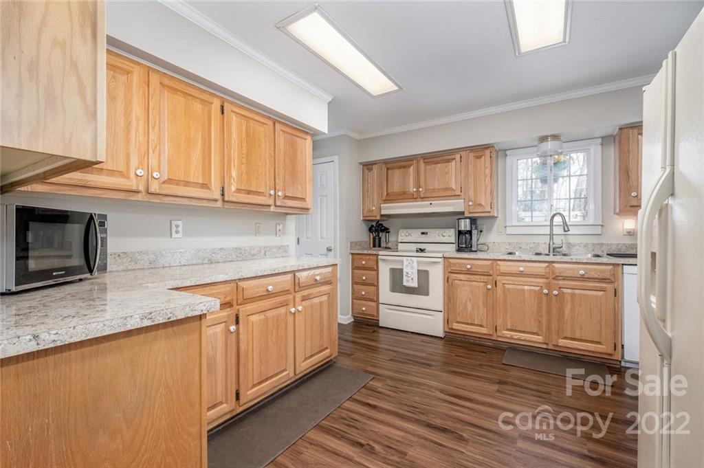 3914 Kiser Island Road Terrell, NC 28682 - Photo 8 of 21 a kitchen with granite countertop wooden cabinets stainless steel appliances a sink and a window