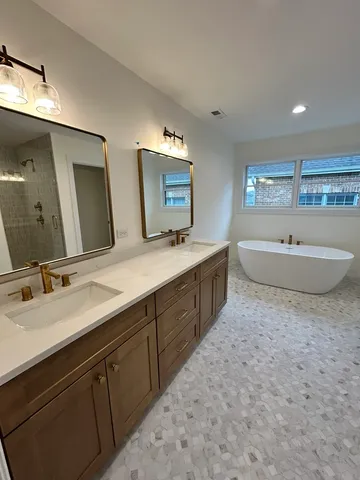 a spacious bathroom with a double vanity sink mirror and bathtub