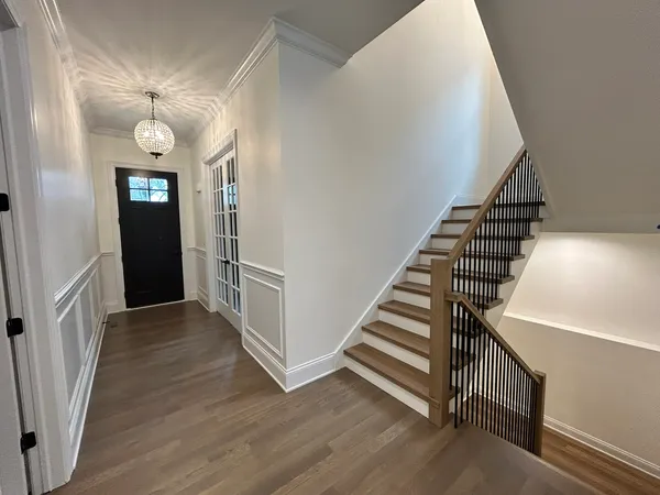 a view of a hallway with entryway wooden floor and front door