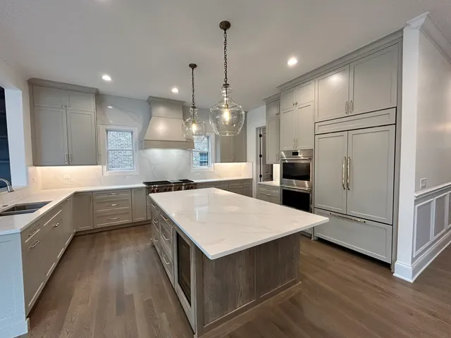 a large kitchen with kitchen island white cabinets and stainless steel appliances