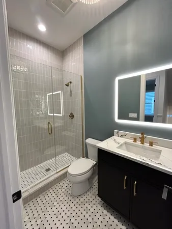 a bathroom with a double vanity sink toilet and shower
