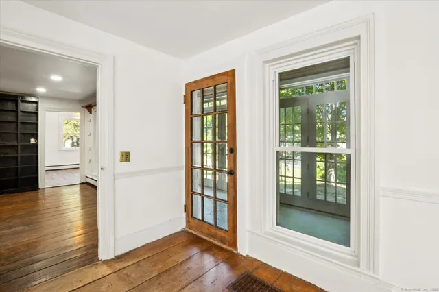 a view of a hallway with wooden floor and glass door