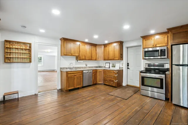 a kitchen with stainless steel appliances kitchen island granite countertop a stove a sink and a refrigerator